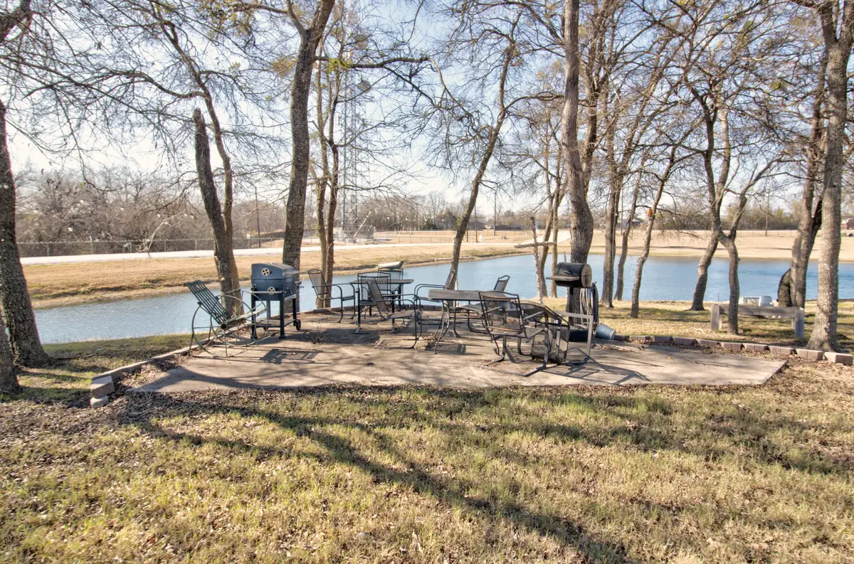 Shaded patio with tables and grills beside the Countryview pond